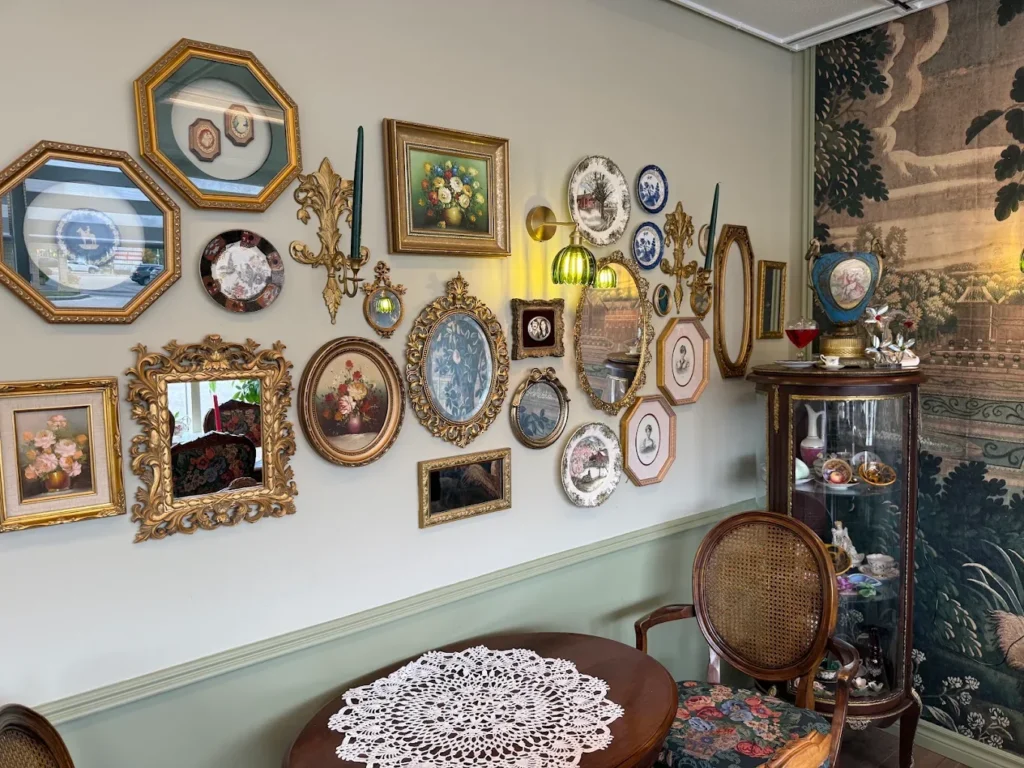 Gallery wall of gilded frames and vintage plates at CakeToronto